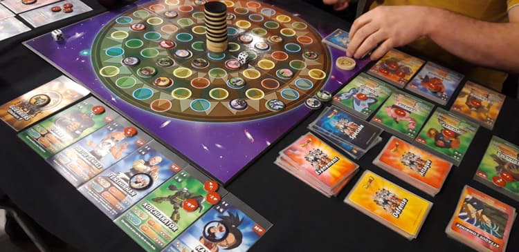Une partie en cours d'un jeu avec un plateau central, des pions et des cartes colorées