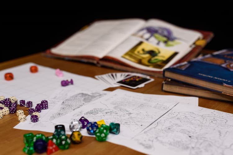 Des livres de jeux de rôles ouverts et des dés multifaces variés